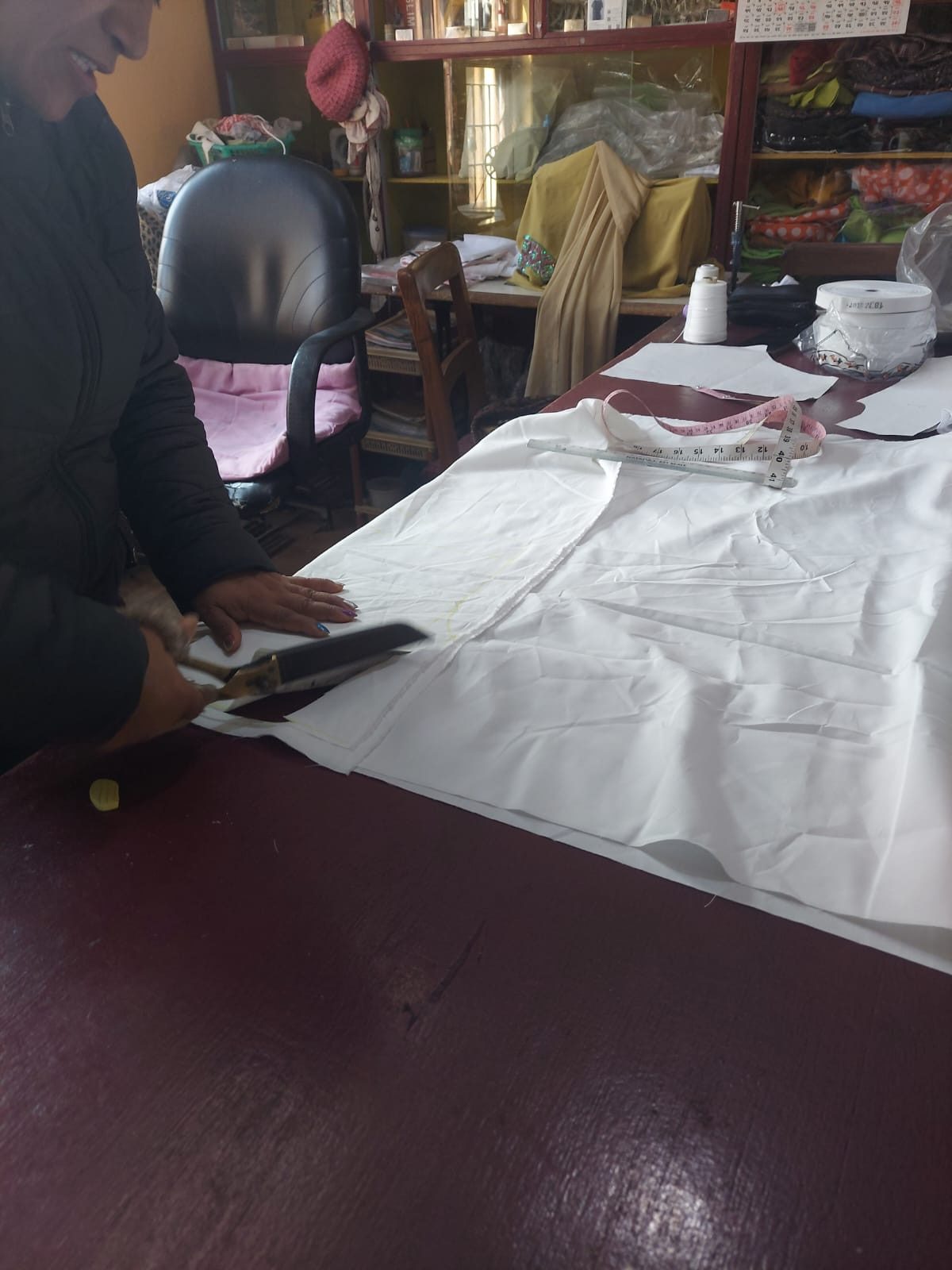 Cutting a cotton pattern piece by hand with shears